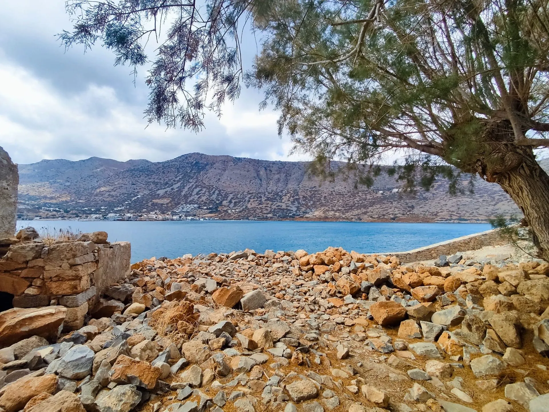 Eine mediterrane Küste mit Bergen im Hintergrund.